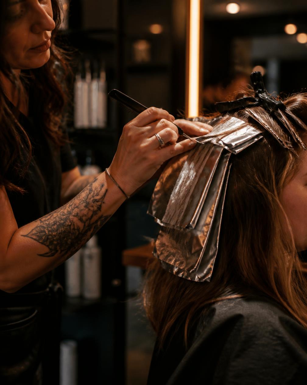 Colourist applying foil highlights to a client in the salon